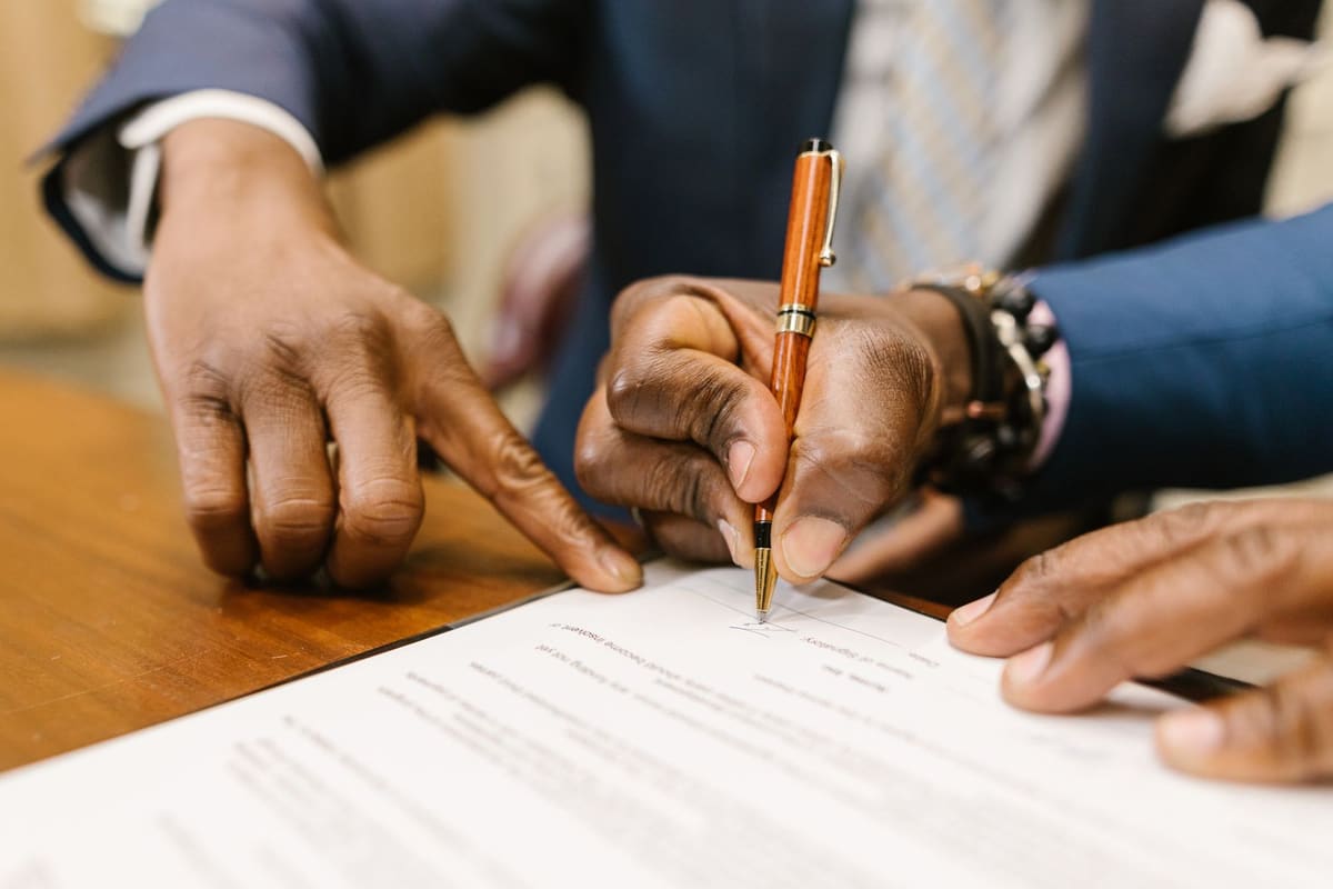 Two people signing a business agreement at a desk